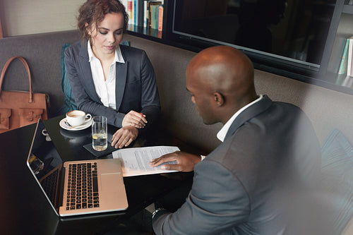 Young people discussing business strategy at cafe