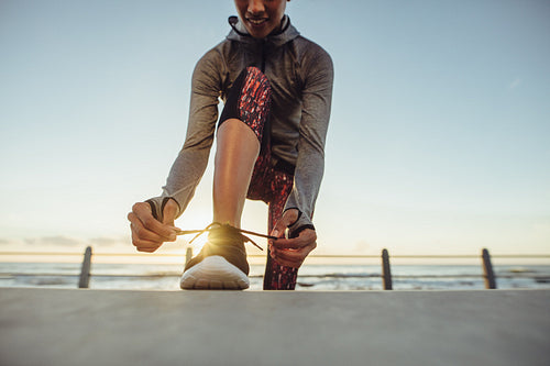 Lacing up her running shoes before workout