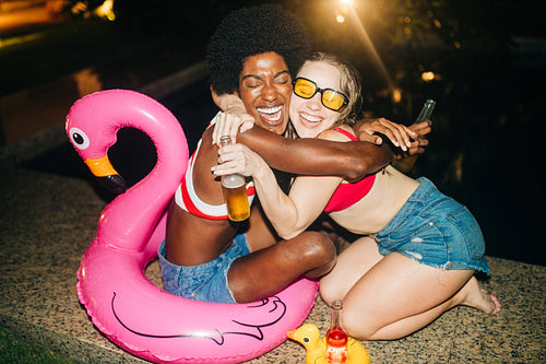 Friends celebrate with pink flamingo by pool
