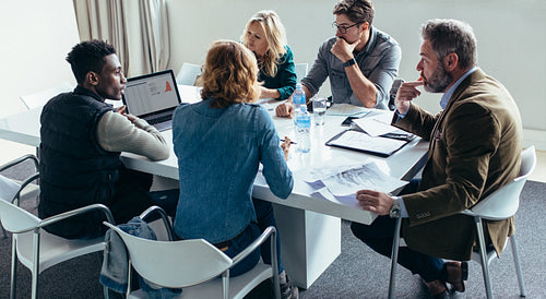 Businessman giving demonstrating on laptop to colleagues
