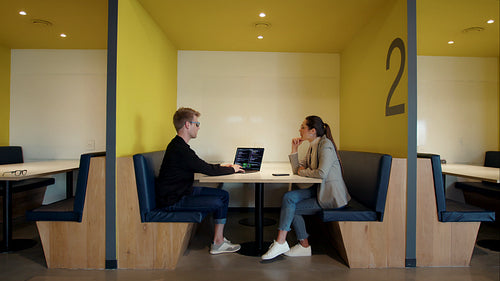 Software engineers discussing a code in a coworking office