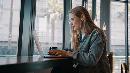 Woman working on laptop at a cafe