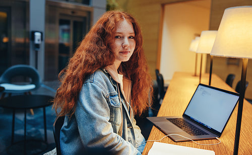 Young woman sitting in library at night