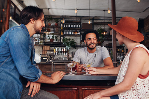Three young friends at cafe having drinks together