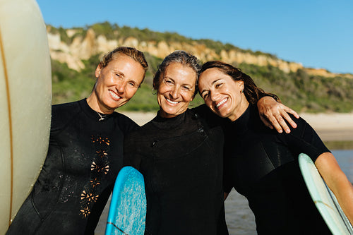 Three women enjoying a surfing holiday together on the beach