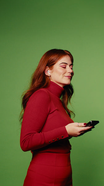 Young woman enjoys music and social media on her smartphone