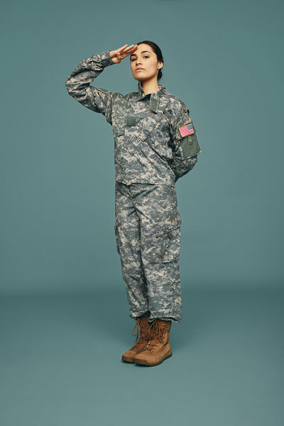 Courageous army soldier saluting in a studio