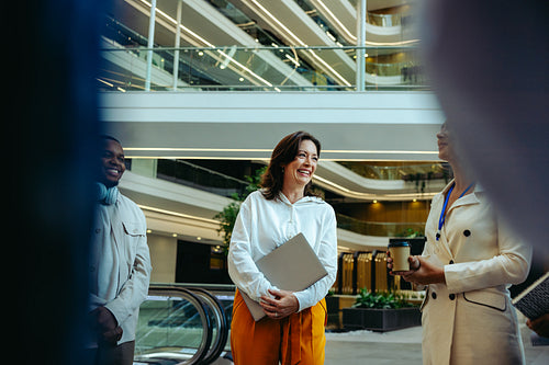 Professional colleagues engaged in a vibrant business meeting in a modern lobby
