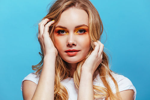 Beautiful young woman posing on blue background