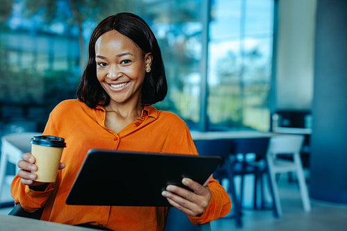 Confident African accountant working with digital tablet in office
