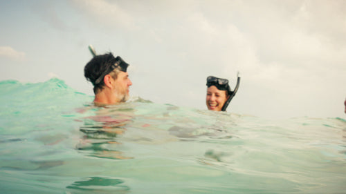 Happy family enjoying a fun snorkeling adventure in crystal clear turquoise ocean water