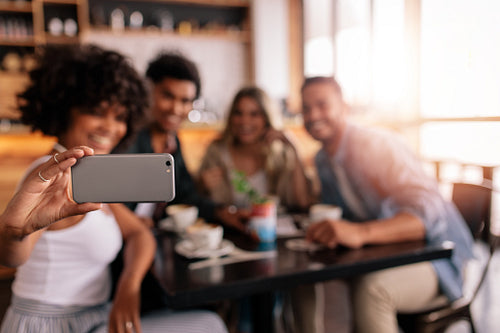 Group of friends at cafe taking selfie