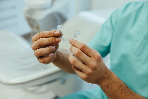 Consultation highlights a dental aligner in hand for teeth correction