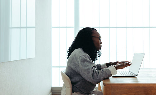African-American professional woman working on a laptop in modern workplace