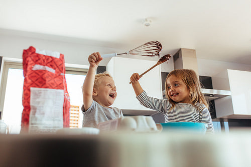 Kids enjoying making cake in kitchen