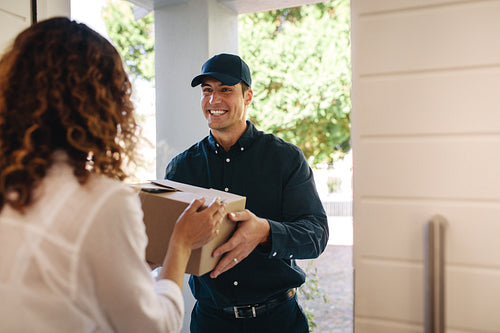Courier worker delivering a parcel to woman