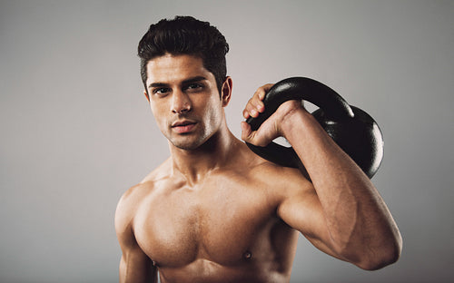 Hispanic fitness male model holding kettle bell