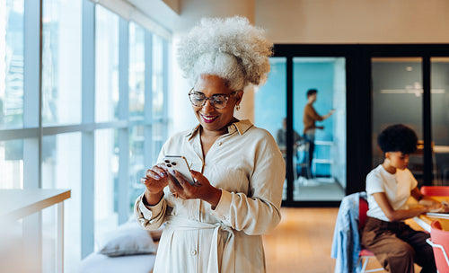 Woman using phone in modern office