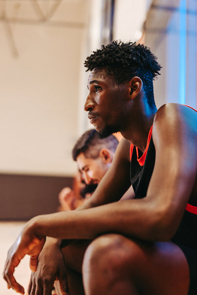 In his zone: Focused basketball player resting on the sideline