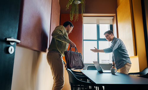 Two business professionals sitting down for a meeting in a modern office
