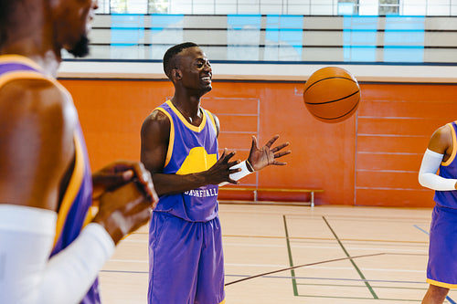 Basketball players practicing on indoor court