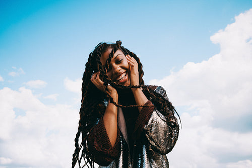 Carefree moment under blue sky: Black woman listening to music