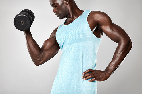 Fitness male model working out with dumbbells