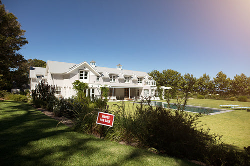 For sale sign in front of the house by real estate agency