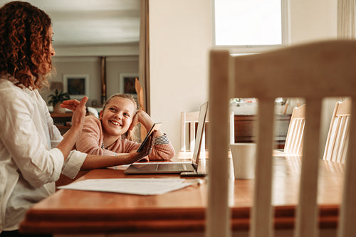Working mother talking with her daughter at home