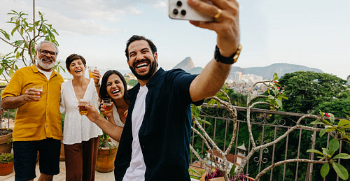 Family enjoying a rooftop party with drinks and a scenic background
