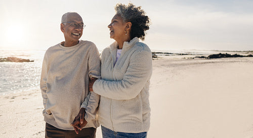 Romantic senior couple laughing together at the beach