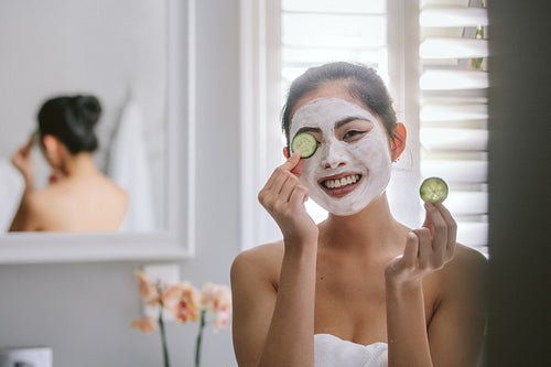 Woman with face pack in bathroom