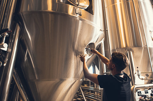 Brewer working with industrial equipment at the brewery
