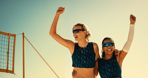 Victorious team usa celebrating beach volleyball championship at sunset