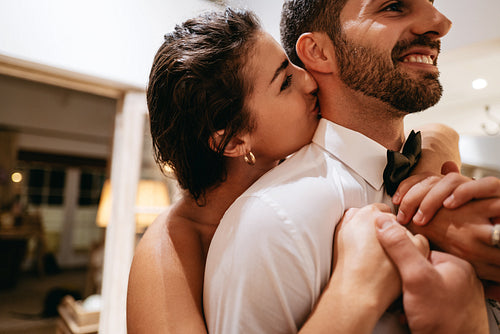 Affectionate young couple standing together in their hotel room