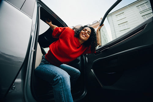 Transportation brings the woman to the city as she gets out of the car