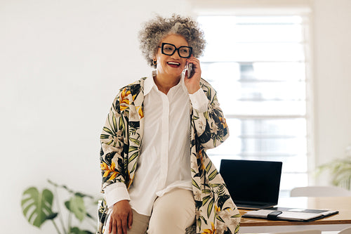 Cheerful businesswoman speaking on the phone in an office