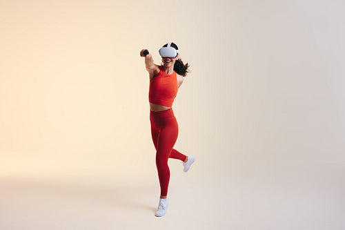 Happy young woman having fun in a virtual reality fitness game