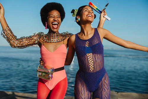 Two women dressed for carnival celebrate at the beach