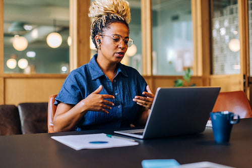 Young woman participating in an online meeting in a casual office setting