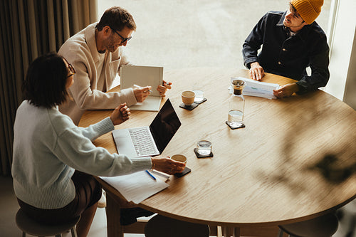 Team reviews project plans around a meeting table