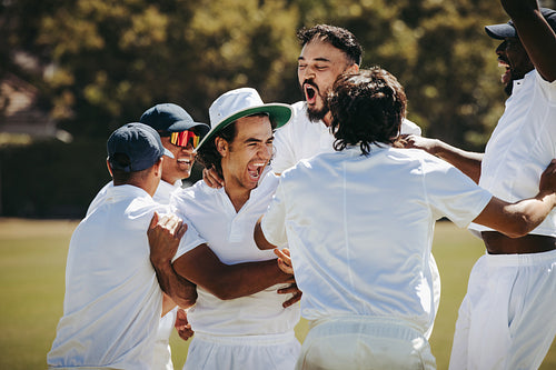Cricket players celebrating their victory with excitement and teamwork outdoors