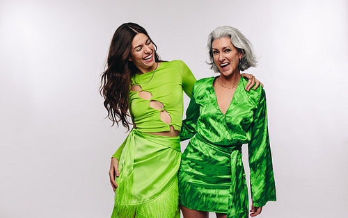Two women laughing and embracing in studio