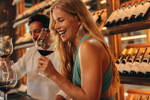 Smiling couple enjoying a wine tasting session in a shop interior,