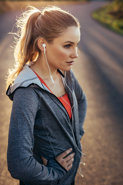 Portrait of a female runner standing on road