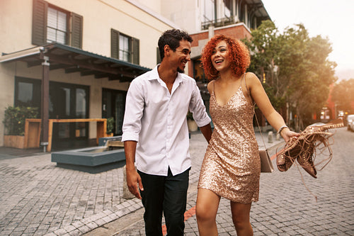 Young couple walking on street holding hand and having fun.