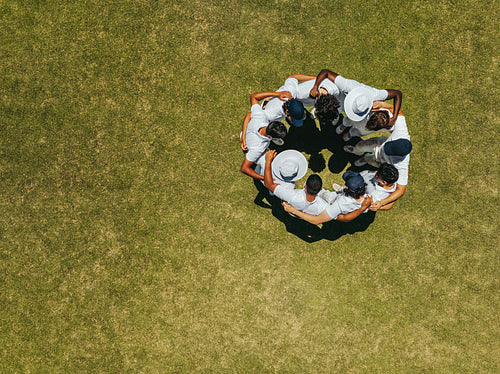 Team huddle on a sports field captured from above
