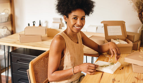 Jewelry business owner packing parcel for delivery