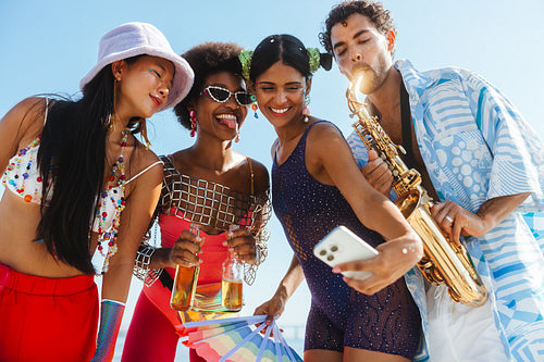 Friends at beach party with saxophone