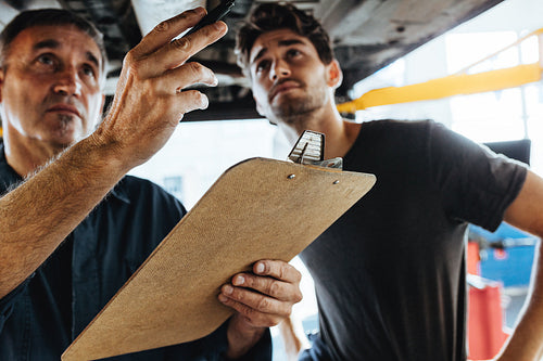 Mechanic inspecting the car in garage